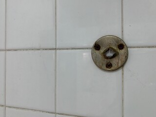An old stainless steel hook with a hole resembling a face.