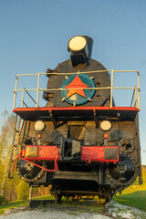 Old steam locomotive with red star on the top of it.