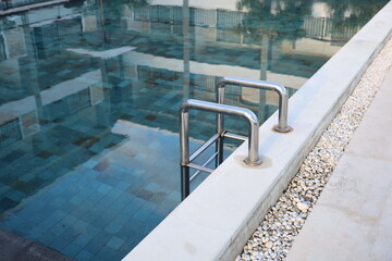 Grab bars ladder in the blue swimming pool