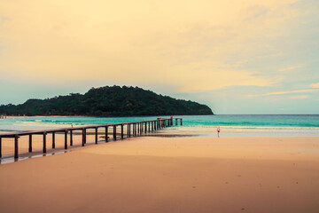 Beautiful sunset over bridge with colored canoe in tropical sea at Koh Kood Island, Trad, Thailand.