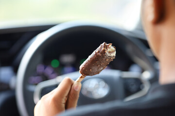 the driver eats ice cream while driving