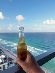 Cool refreshing bottle beer on a balcony with view of the beaches of Cancun stock photo