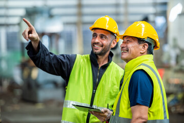 Two professional engineer worker technician assistant in helmet inspection check old machine construction factory with colleague manager. check old machinery production construction operating