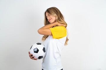 Young beautiful woman wearing football T-shirt over white background got back pain