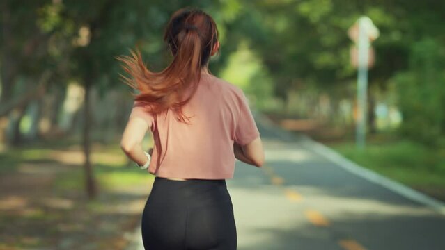 B roll - Runner young woman running in the summer park, Close up fitness female jogging outdoor. exercising outdoors, slow motion.