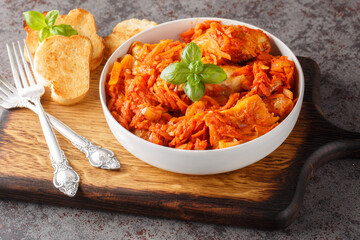 Homemade fish stew with vegetables in spicy tomato sauce served with toast close-up on a wooden...