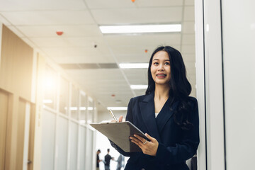 Woman holds a chick list and a pen. Stand up in the modern office. Women leader the new company self-confident. Professional Confident business expert.