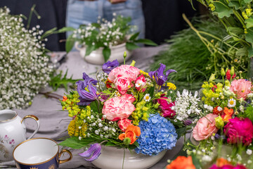 Gesteck aus frischen Blumen in einer Schale aus Keramik, Pfingstrose, Kamille, Margeriten, Clematis...