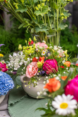 Gesteck aus frischen Blumen in einer Schale aus Keramik, Pfingstrose, Kamille, Margeriten, Clematis und Schleierkraut als Dekoration für den Tisch, Blumengesteck 