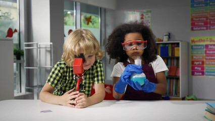 Children learning and doing science experiments in classroom. 