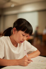 Fototapeta na wymiar 学校の自習室で宿題をしている小学生の女の子の様子