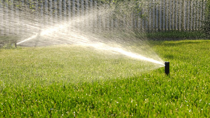 Automatic garden irrigation system watering lawn with adjustable head. Automatic equipment for...