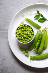 Ripe green peas on a white plate.