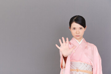 手を出して制止する着物を着た女性