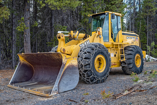 Crescent Lake, Oregon, USA - May 15, 2023: A parked John Deere 744h wheel loader with tire chains