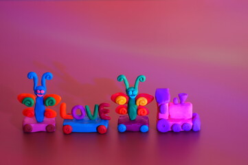 A toy train with colorful butterflies and the inscription love. Children's toys. Decorations for the holiday.