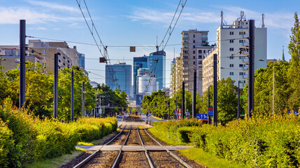 Wola and Srodmiescie downtown business districts panorama with skyscrapers along tram track at Aleja Jana Pawla II avenue in Warsaw in Poland