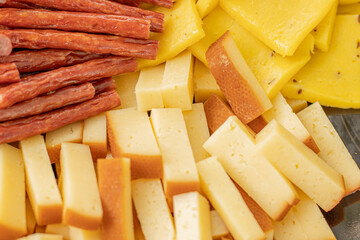 Cheese snacks in one container. Sliced cheese in different shapes. Cheese board for the celebration