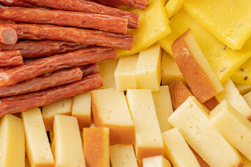 Cheese snacks in one container. Sliced cheese in different shapes. Cheese board for the celebration