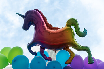 Balon w kształcie jednorożca, w kolorach tęczy na tle Warszawy. Parada LGBT przemarsz ulicami Warszawy