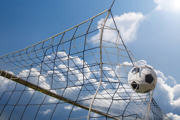 Symbolbild Tor im Fußball: Ball landet hoch im Netz eines Fußballtores