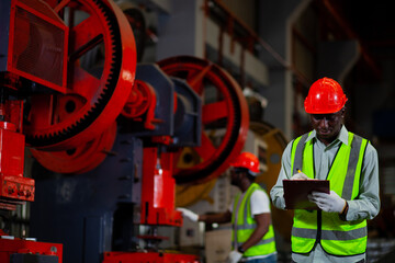 Worker or male industrial engineer Two African Americans wearing safety gear . Talk about a project in a heavy industrial plant.