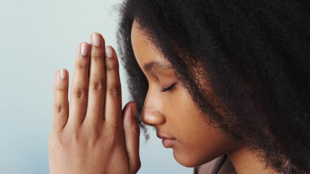 African American young woman or girl pray to God with closed eyes. Religion and faith concept.