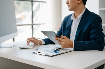 Business man hands is typing on a laptop and holding smartphone at office