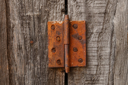 Old rusty hinge on a wooden door. Old rustic background