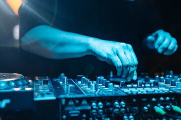 DJ Hands creating and regulating music on dj console mixer in concert