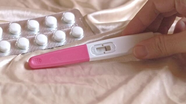 A hand checking a pregnancy test showing negative result showing contraception and women basic healthcare