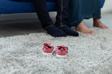 Close up of  small  pink baby shoes.on a grey rug,  enjoying future parenthood. family concept.