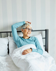 senior bed woman home elderly caucasian portrait adult happy retirement mature old bedroom smiling...