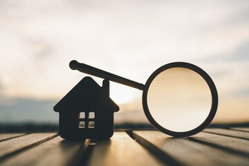 Magnifying glass and house model, house selection, real estate concept.	
