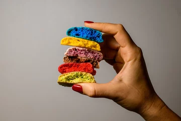 Gordijnen Set of six tasty multicolored blanks of macaron broken in half in female hands © fesenko