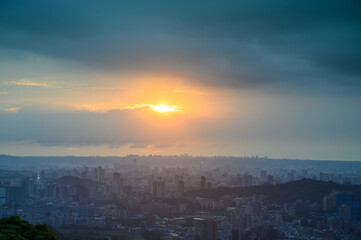 Rolling fast moving dark clouds. Orange sunset. At dusk, the view of Taipei City on a cloudy day.