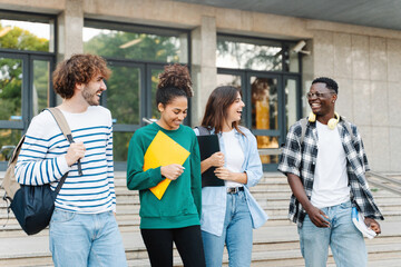 Group of University Students Walking after classes Holding Books And Laughing