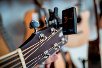 Young musician tuning a classical guitar in a guitar shop