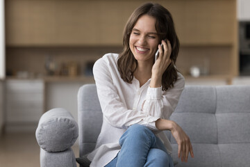 Happy woman blab on smartphone, lead pleasant personal conversation rest on couch, smile, share...