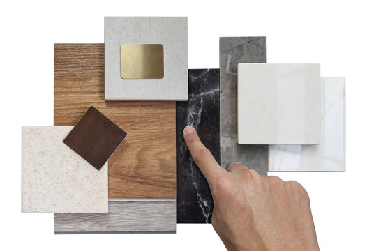 interior designer chooses luxury sample materials including black and gery marble stones, wooden vinyl flooring tiles, grainy quartz, ceramic tiles isolated on background with clipping path.