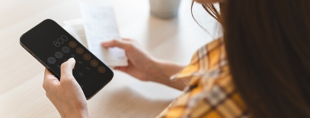 Closely Examining Financial Matters: Person's Hand Engaged in Precise Calculation of Bills Using a Calculator on mobile application