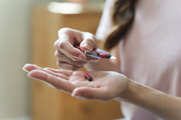 Healthcare Harmony: Close-Up Hands Holding Medication and Water Glass for Optimal Wellness,...