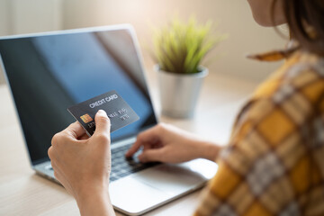 Connected at Home: Close-Up of Hand Holding Credit Card, Making Online Payment on Laptop for Convenient Online Shopping and E-commerce Experience