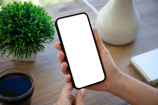 female hand hold phone with isolated screen background table house