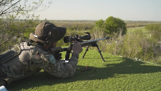 the shooter shoots at the target from a prone position at sunset