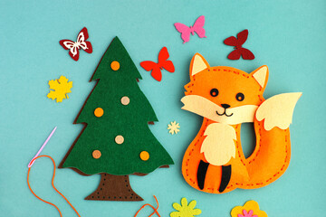 Crafts from felt in the form of a fox and spruce. Felt for needlework and hobbies. Making crafts from felt close-up.