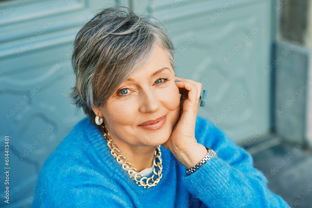 Sticker outdoor portrait of beautiful 55 - 60 year old woman, wearing blue pullover