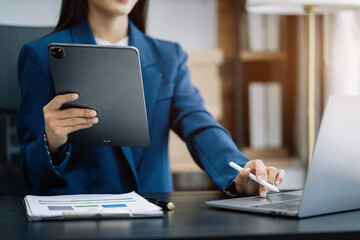 woman using mobile phone in modern office with laptop and digital tablet computer with VR icon diagram at office in morning light.