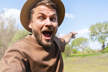 Happy delight male facial expressions, portrait of man wearing straw hat with wide opened eyes and mouth.