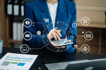 Female businessman working with holding a pen and using a calculator to calculate the numbers of...